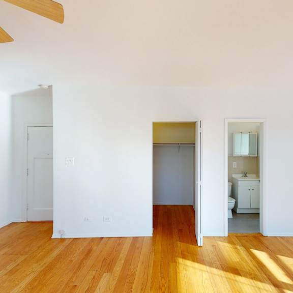 a room with wooden floors and a ceiling fan.