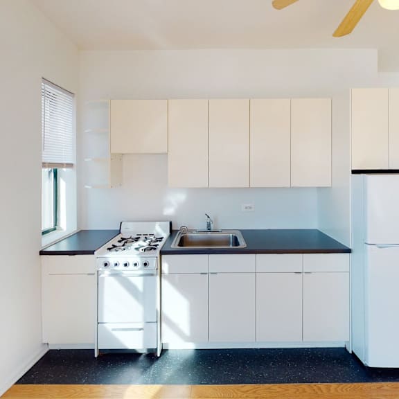 a kitchen with white cabinets and a black countertop.