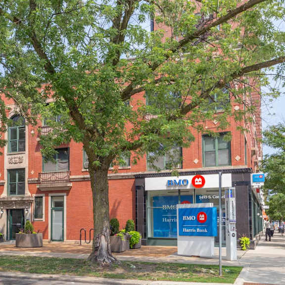 a red brick building with a bank in front.