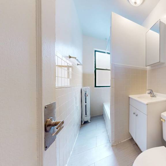 a white bathroom with a toilet, sink, and bathtub.