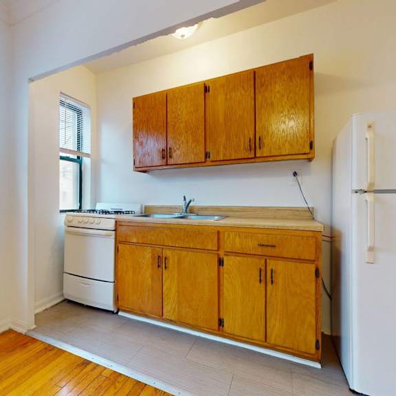 a kitchen with wooden cabinets and a white fridge.