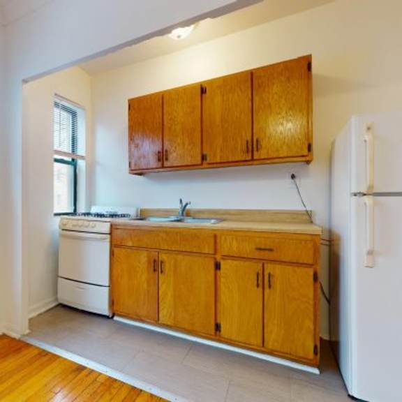 a kitchen with wooden cabinets and a white refrigerator.
