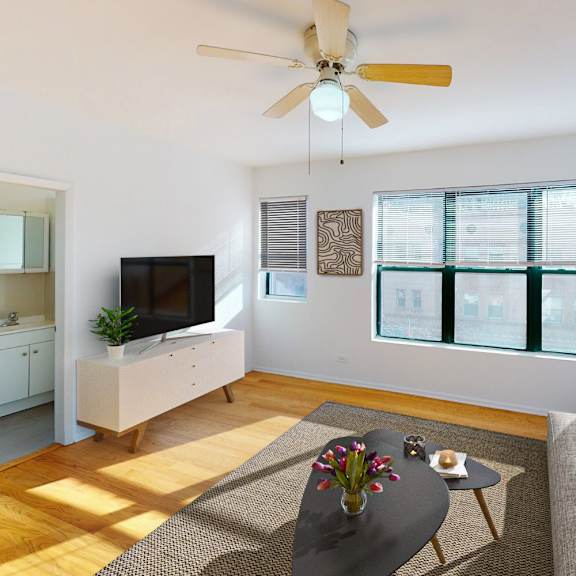 a living room with a grey sofa, a coffee table, a television, and a ceiling fan.