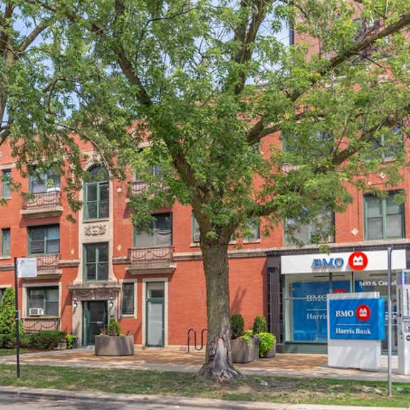 a red brick building with a bank in front.
