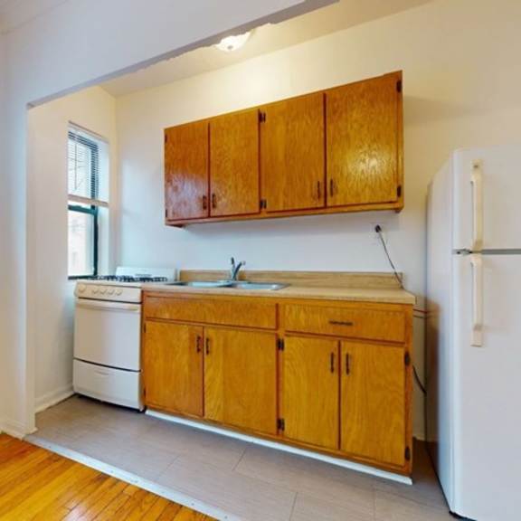 a kitchen with wooden cabinets and a white refrigerator.