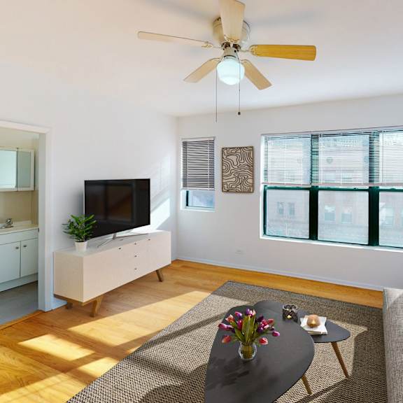 a living room with a grey sofa, a coffee table, a television, and a ceiling fan.