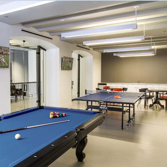 a pool table is in the middle of a room with a mirrored wall.