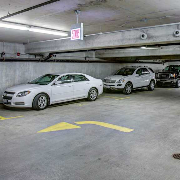 a white car is parked in a parking garage next to a yellow line.