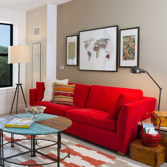 a living room with a red couch and a coffee table.