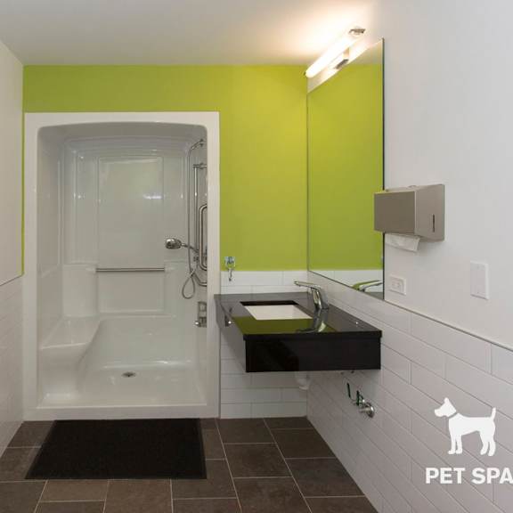 a bathroom with a green wall and a white tub.