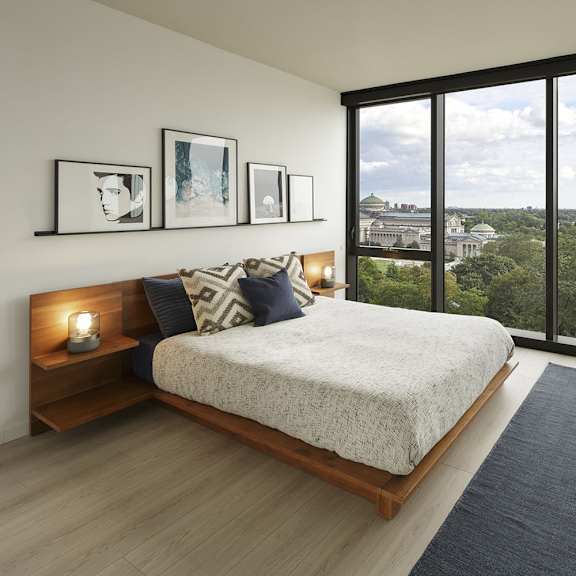 a bedroom with a large bed and a view of the city.