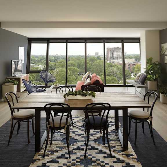 a dining room with a table set for six with a view of the city.