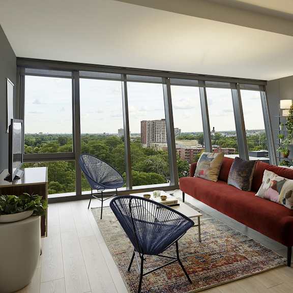 a living room with a red couch and a view of the city.