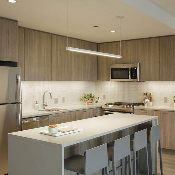 a modern kitchen with a refrigerator, sink, and dining table.