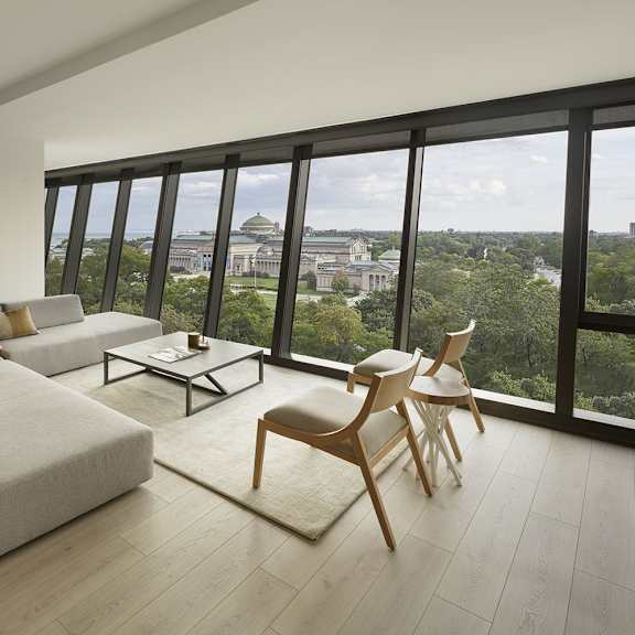 a living room with a couch, chairs, and a view of the city.