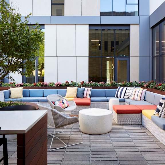 a modern outdoor seating area with a variety of colorful cushions and chairs.
