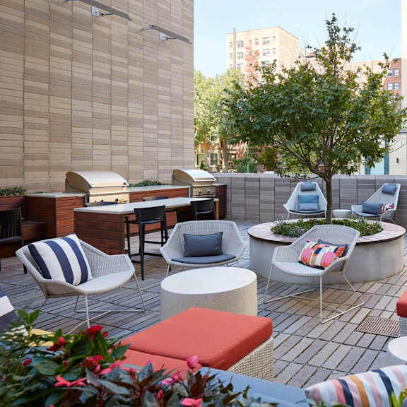a patio with a table and chairs surrounded by plants.