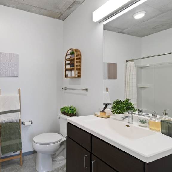 a bathroom with a toilet, sink, and mirror.