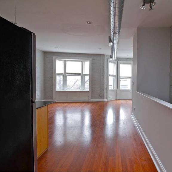 a room with a black door and wooden floors.