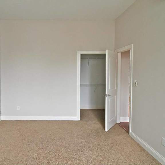 a room with a carpeted floor and a white brick wall.