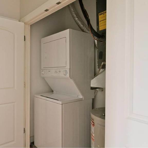 a white door is open to reveal a white appliance.