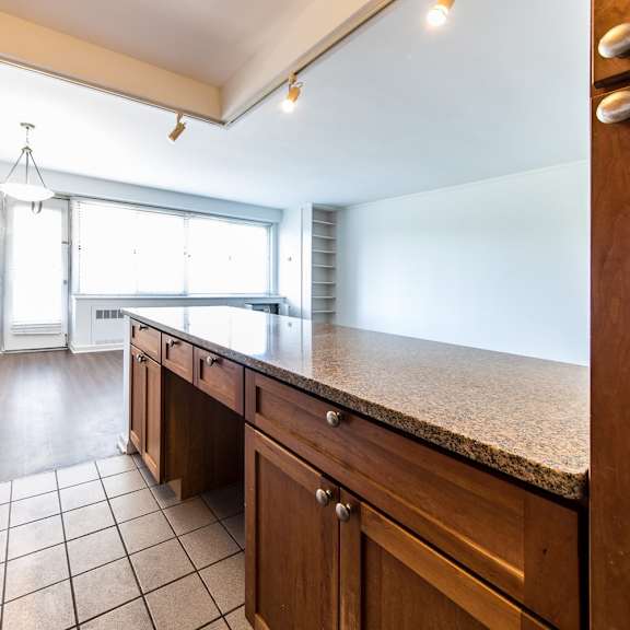 a kitchen with wooden cabinets and a tiled floor.