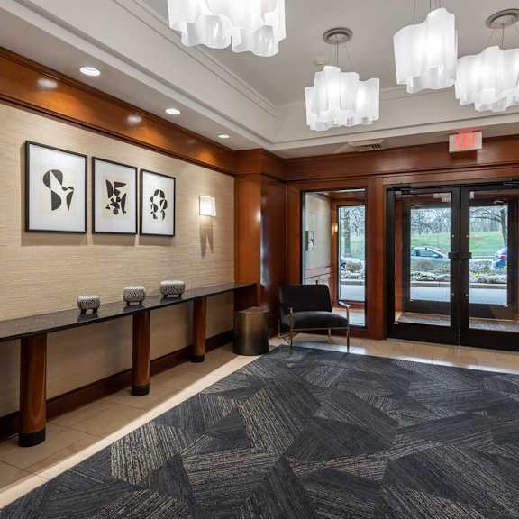 a hallway with a black carpet and wooden doors.