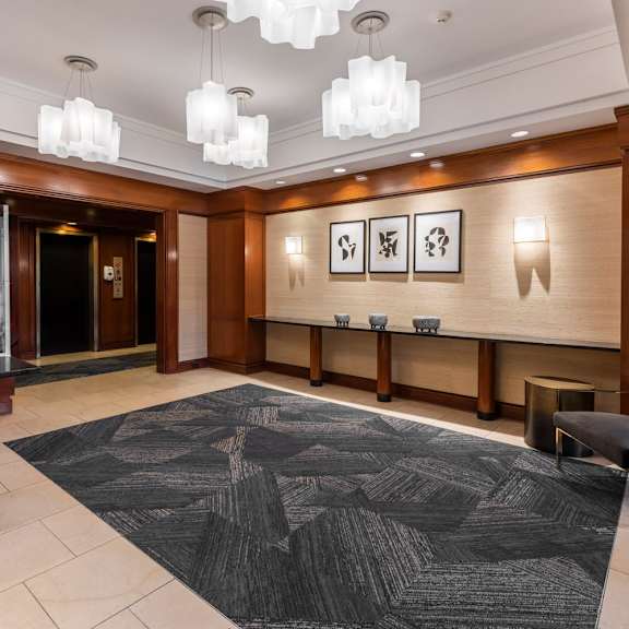 a black and white patterned rug is on the floor of a well-lit lobby.