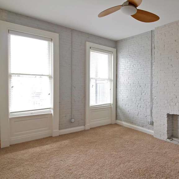 a room with a white brick wall and a ceiling fan.