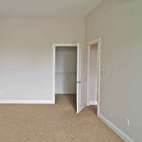 a room with a carpeted floor and a white brick wall.