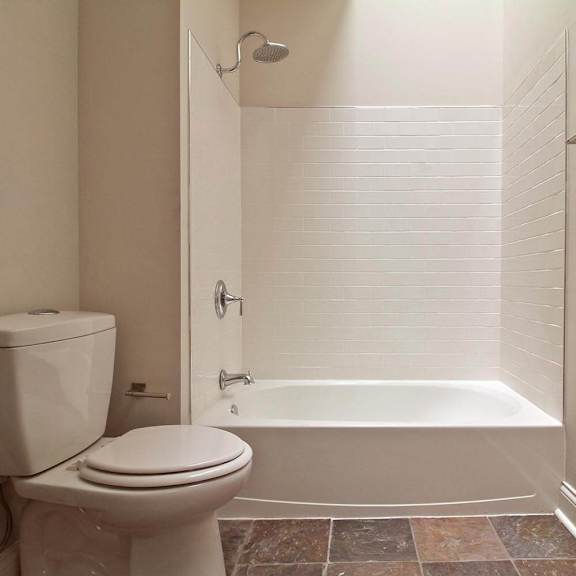 a white toilet sits next to a white bathtub in a bathroom.