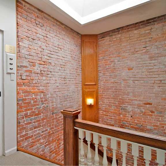 a room with a brick wall and a white door.