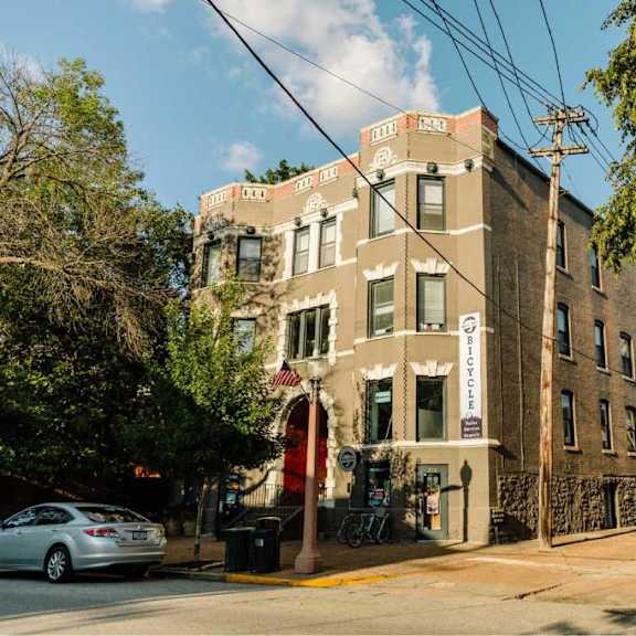 a street view of a building with a car parked in front.