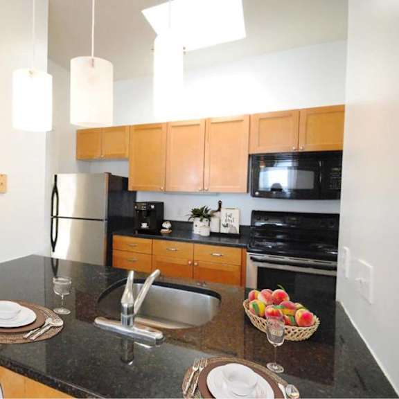 a kitchen with a black granite countertop and wooden cabinets.