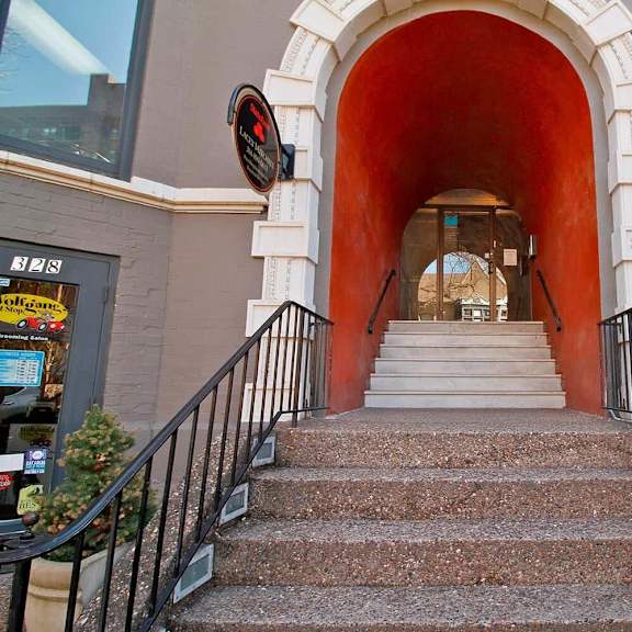 a set of stairs leads up to a building with a red arch.