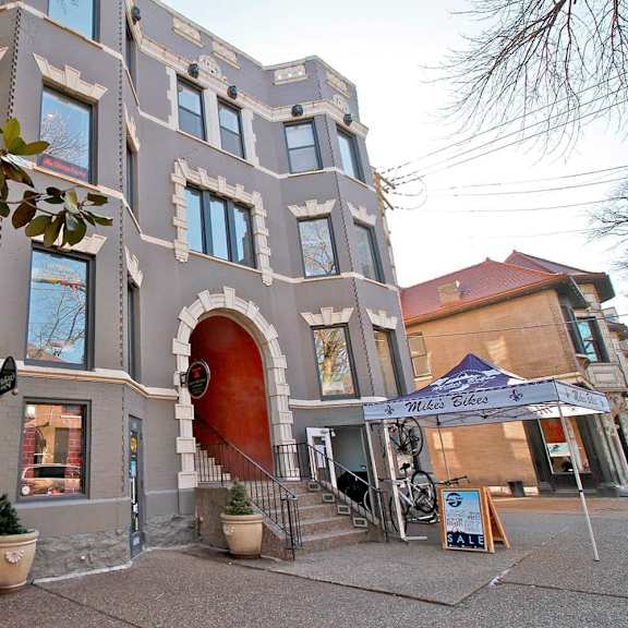 a building with a red door and a sign that says "mile bikes" in front of it.