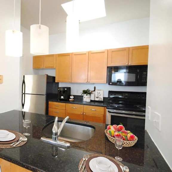 a kitchen with a black granite countertop and wooden cabinets.