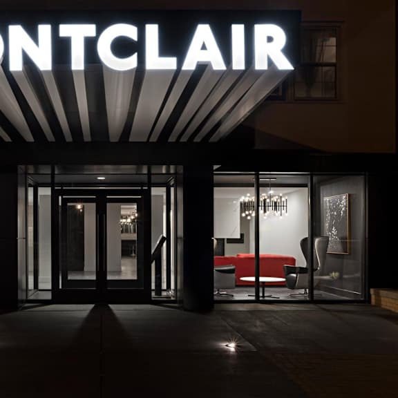the montclair storefront is well-lit and inviting with its large glass doors and chandeliers.