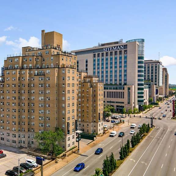a city street with cars and buildings including one with the word