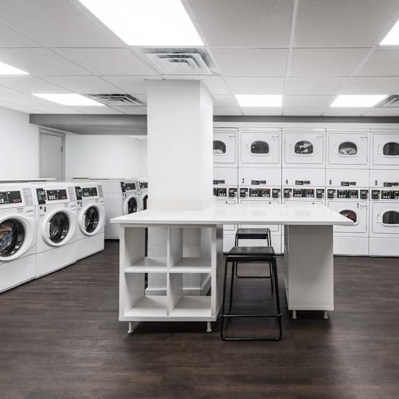 a laundry room with washing machines and a counter.