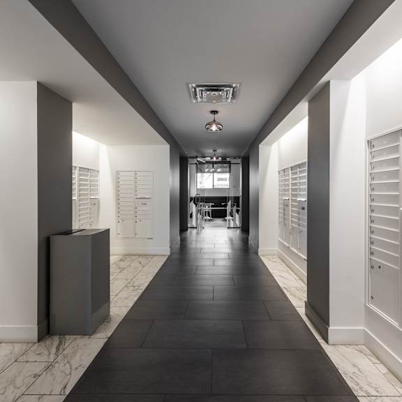 a long hallway with white walls and black floors.