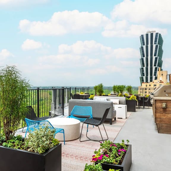 a rooftop patio with a table and chairs overlooking a cityscape.