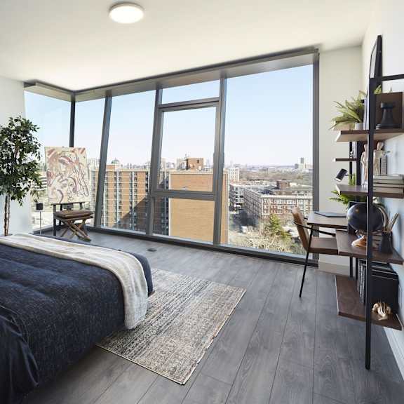a bedroom with a large bed and a view of the city.