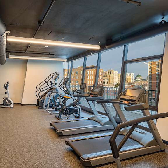 a gym with treadmills, exercise bikes, and other equipment.