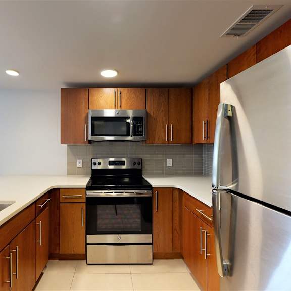 a modern kitchen with wooden cabinets and stainless steel appliances.