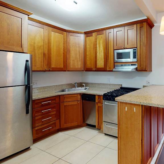 a kitchen with wooden cabinets and a stainless steel refrigerator.