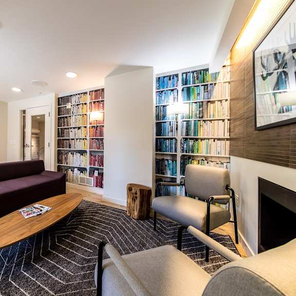 a living room with a purple couch and a fireplace.