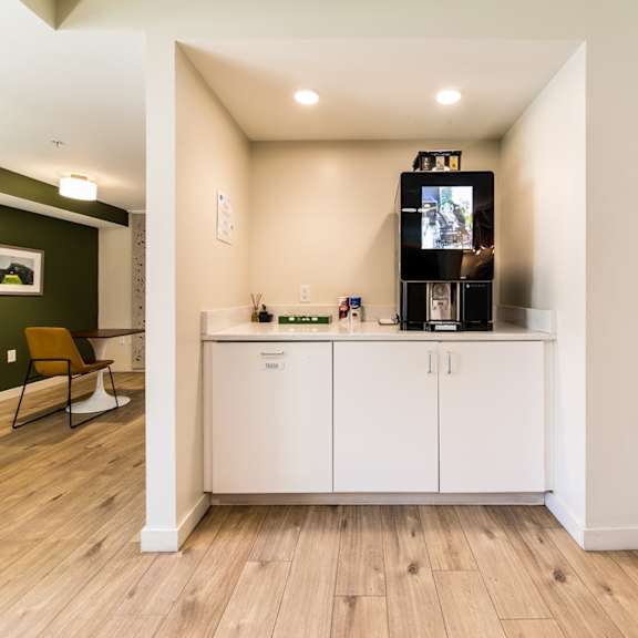 a kitchen with white cabinets and a wooden floor.