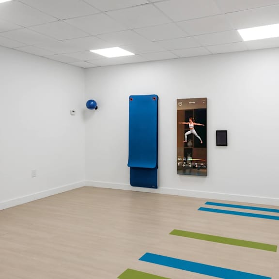 a yoga studio with a blue mat and a poster on the wall.