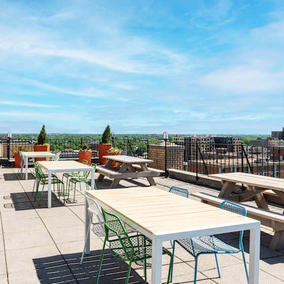 a patio with tables and chairs overlooking a cityscape.